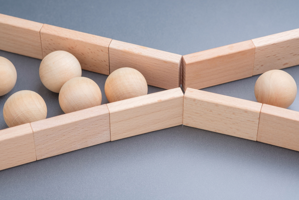 Close up of wooden balls blocked at a narrow junction, symbolizing a bottleneck of Usenet speeds.