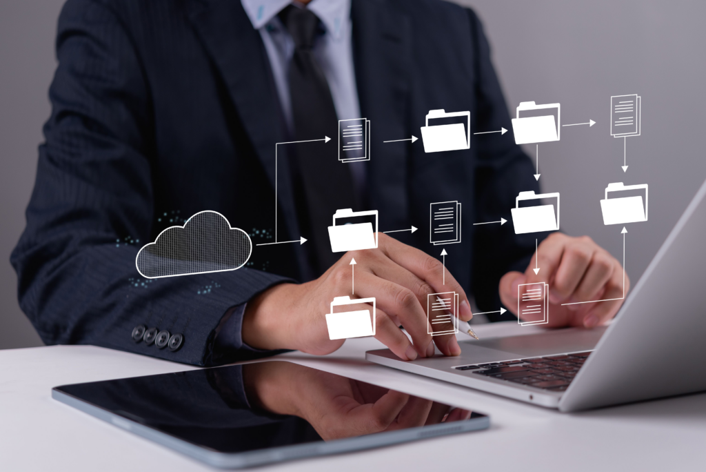 Hologram of folder and file icons hovering over a laptop and tablet and being managed by a person in a suit. Representation of a Usenet server.
